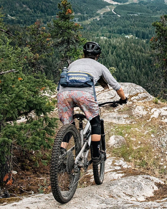 Een mountainbiker met een tas om waarop patagonia zichtbaar is.